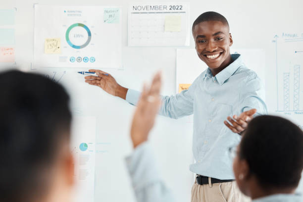 istock Training, black man and leader presentation, discussion for marketing data and workshop with chart, talking and office. Brainstorming, male trainer and coach speaking, business finance and smile. 1455070820