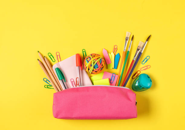 istock Back to school concept. Pencil case with various school stationery items on bright yellow background top view 1455072047