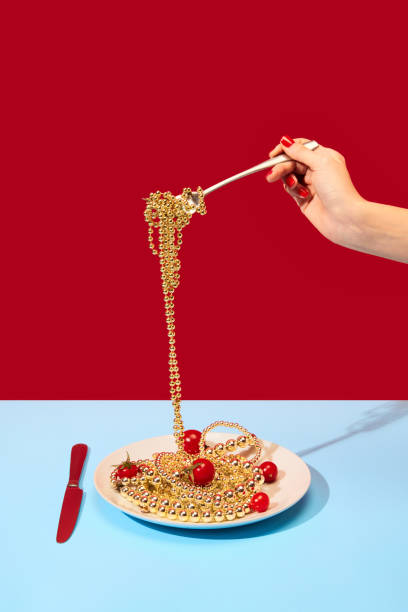 Female hand spinning on fork necklace symbolizing spaghetti in bright blue tablecloth over red background. Food pop art photography.