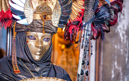 Venice, Italy - February 10, 2018: Two beautiful venetian carnival masks with the famous St Mark Basilica and Doge Palace in the background