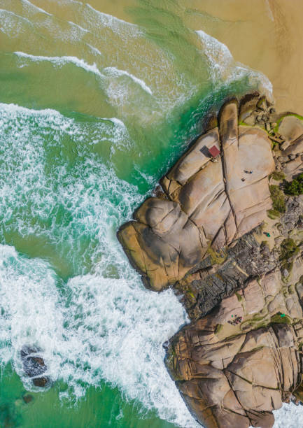 Aerial view of rocks and waves in Joaquina beach Aerial view of rocks and waves in Joaquina beach, Florianopolis, Santa Catarina, Brazil joaquina beach in florianopolis santa catarina brazil stock pictures, royalty-free photos & images