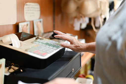 Close up of old woman hand on the cash register, Female hand on the cash register in a store.