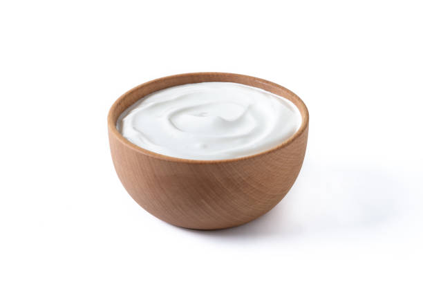 Greek yogurt in wooden bowl isolated on white background stock photo