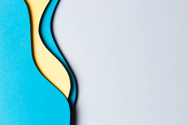 istock Abstract colored paper texture background. Minimal paper cut composition with layers of geometric shapes and lines in yellow and light blue colors. Top view 1455077219