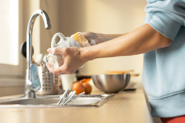 Woman washing dirty dishes stock photo
