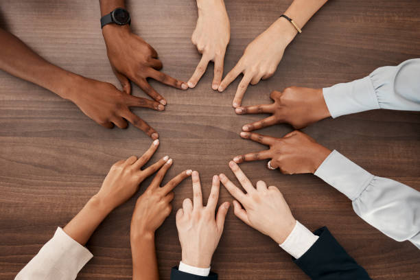 istock Team, hands or peace star sign with diversity teamwork, collaboration or team building on desk in office. Business people, support or business meeting for success partnership, community goal or trust 1455081663