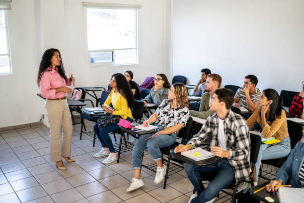 istock Mid adult teacher explaining lesson to her students in the classroom at university 1455082361