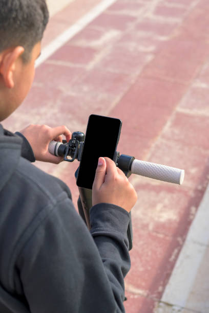 istock teenager using smart phone, on electric scooter, eco mobility concept 1455086582