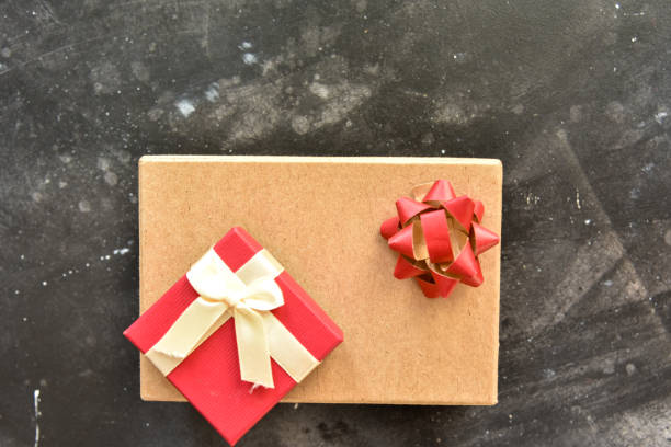 istock Gift  box on a  black background, decorated with a textured bow and feathers,creating a romantic atmosphere for anniversary presents,valentine and birthday gift, post cards. Top view,copy space 1455086733