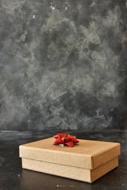 istock Gift box on a dark background, decorated with a textured bow and feathers, creating a romantic atmosphere for anniversary presents, valentine and birthday gift, post cards. Close up, copy space 1455086959