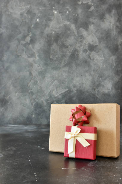 istock Gift box on a dark background, decorated with a textured bow and feathers, creating a romantic atmosphere for anniversary presents, valentine and birthday gift, post cards. Close up, copy space 1455087519