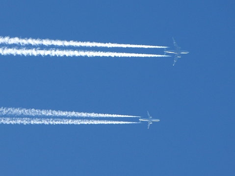 two planes flying side by side and their contrails in the sky