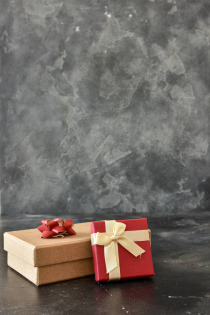 istock Gift box on a dark background, decorated with a textured bow and feathers, creating a romantic atmosphere for anniversary presents, valentine and birthday gift, post cards. Close up, copy space 1455087543