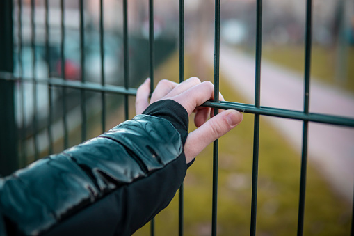 Caucasian girl holding a fence