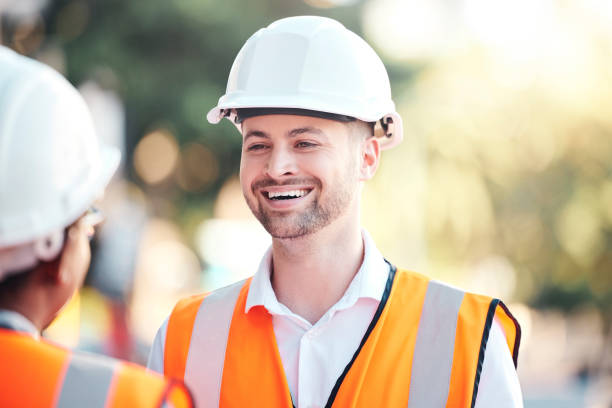 istock Safety, architecture and happy engineer at a construction site talking or speaking at a home renovation. Smile, contractor and engineering partner in conversation at an outdoor building project job 1455089896