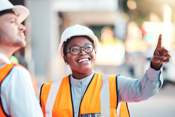istock Engineering, architecture and industry employees planning a maintenance, architect or construction project. Development, partnership and black woman working on a civil plan at outdoor industrial site 1455089906