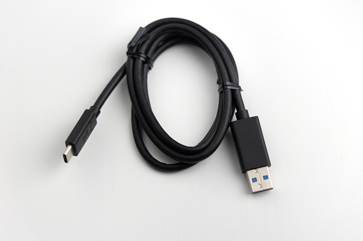 New coiled black USB accessory cable with large and small connectors against a white background