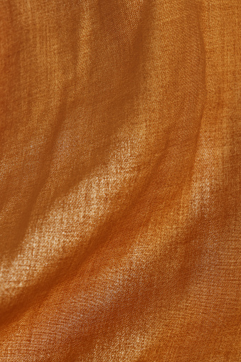 Background texture of bright orange fleece, soft napped insulating fabric made of polyester, wavy pattern, top view