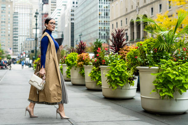 Nicely dressed businesswoman seen exiting the building in Manhattan after work stock photo