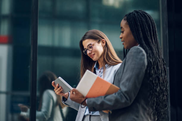 istock Two multiracial business woman meeting outside and using a tablet 1455097089