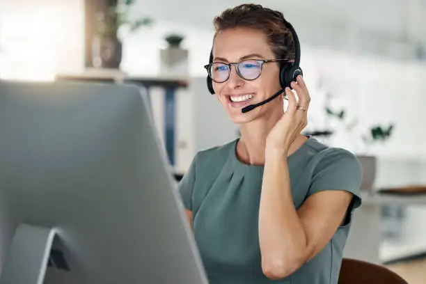 Happy, call center and computer, woman and headphones at desk, customer support or sales for telemarketing company. Mature agent or consultant, office and working, communication and customer service