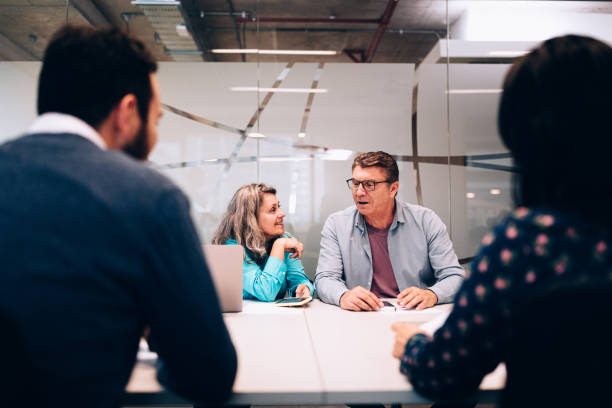 istock Coworkers whispering during business meeting 1455098677