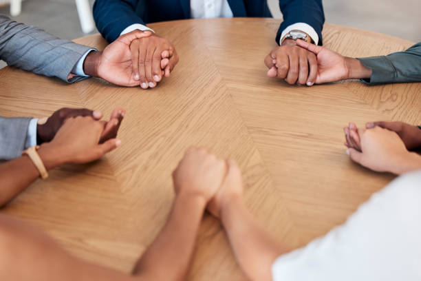 istock Teamwork, trust and business people holding hands in meeting for support, unity and agreement. Collaboration, diversity and group of workers at desk with joined hands in circle, united together 1455106941