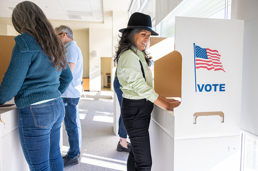 A Hispanic woman voting at a local community center.
