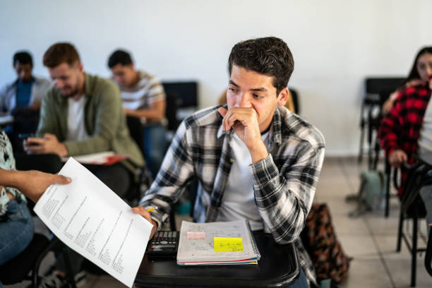 Young man receiving his test result in the classroom at university