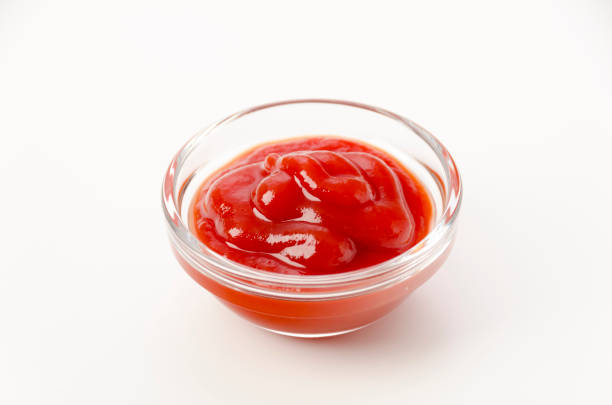 istock tomato ketchup in a small glass bowl on a white background 1455111555