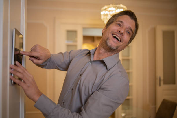 istock Man adjusts the temperature at home with a device on the wall 1455111615