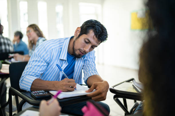 istock Mid adult man studying in the classroom at university 1455112261