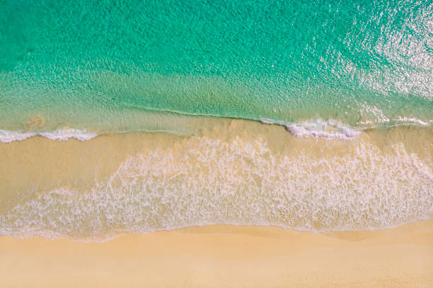 istock Beach and azure sea with waves from top view. 1455115332