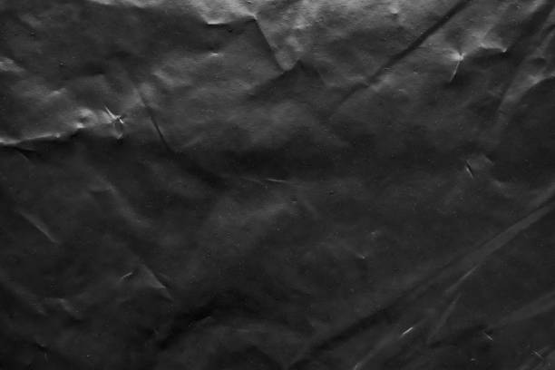 istock transparent plastic bag wrap overlay texture on black background 1455118432
