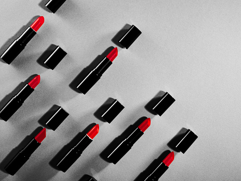 Seamless pattern of red lipstick and caps on