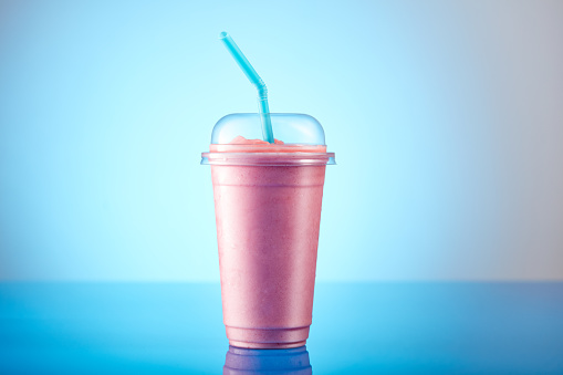 Strawberry smoothie in plastic transparent cup