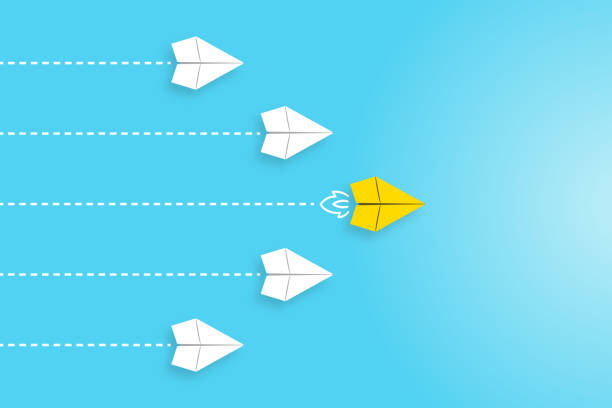istock Leadership concepts with yellow paper airplane leading among white 1455123379