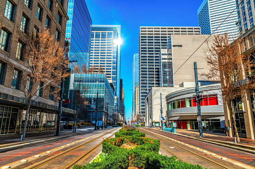 The famous Main Street in Houston Texas with a set of lightrail tracks on either side of the center median.