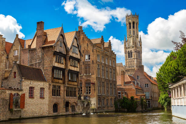 canal in bruges and belfry tower - belfort imagens e fotografias de stock