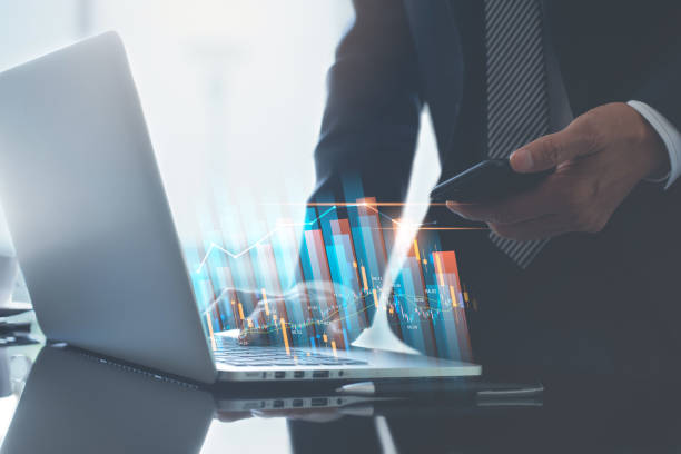 istock Business finance technology concept. Businessman using digital tablet and laptop computer analyzing sales data with economic growth, financial graph 1455125882