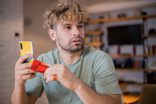 istock Man using his credit card to shop online 1455126331