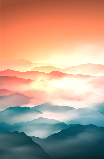 Mountains with fog in the rays of the sun at sunset