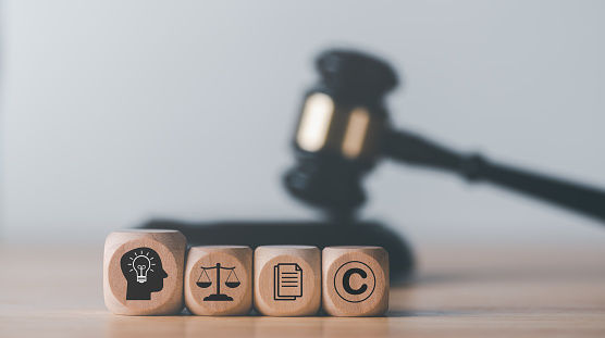 wooden blocks and Wooden judge gavel on the table, concept of copyright or intellectual property patent protection of copyright infringement proprietary declaration Legitimate innovations