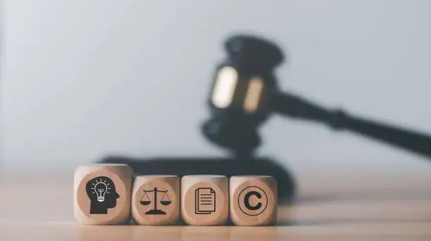 Photo of wooden blocks and Wooden judge gavel on the table, concept of copyright or intellectual property patent protection of copyright infringement proprietary declaration Legitimate innovations