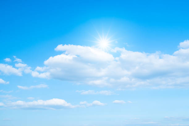 White clouds and sun with sunlight on blue sky.