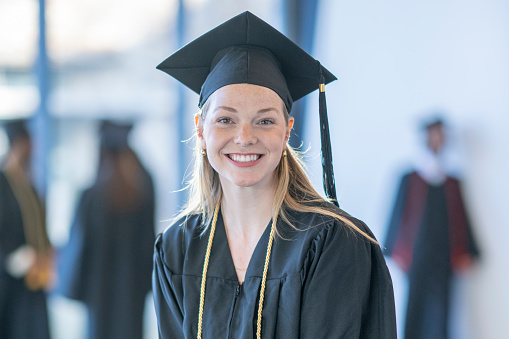 Portrait of a student holding her diploma on graduation day