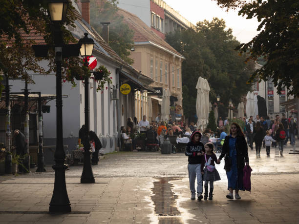 Selective blur on a Serbian family, a mother and her kids, walking by the Gospodska ulica street, the main street of Zemun. Picture of a family walking on the Gospodska Ulica of Zemun, in Belgrade, Serbia. Zemun  is a municipality in the city of Belgrade. Zemun was a separate town that was absorbed into Belgrade in 1934. It lies on the right bank of the Danube river, upstream from downtown Belgrade. The development of New Belgrade in the late 20th century expanded the continuous urban area of Belgrade and merged it with Zemun. majkav stock pictures, royalty-free photos & images