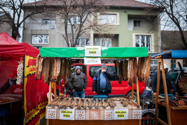 стенд рыбака на рынке сланинияда какалево, продающего копченую и вяленую рыбу, а также вяленую рыбу, также называемую на сербском языке dimljen - market market stall shopping people стоковые фото и изображения