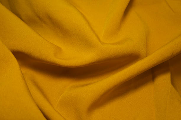 istock Yellow fabric background. Yellow cloth waves background texture. Yellow fabric cloth textile material. 1455148915