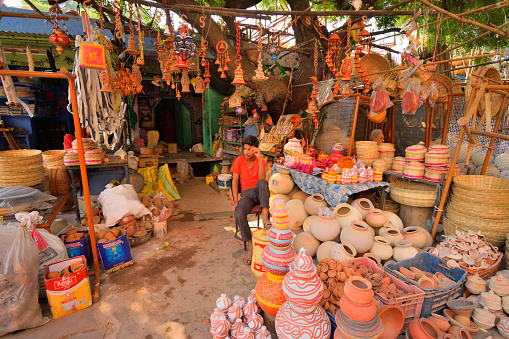 Jodhpur, India - November 05, 2017: A man selling colorful pottery items in his shop.